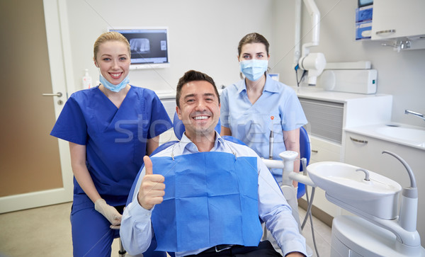 happy female dentists with man patient at clinic Stock photo © dolgachov