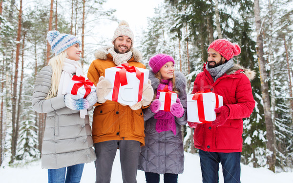 happy friends with gifts in snowy winter forest Stock photo © dolgachov