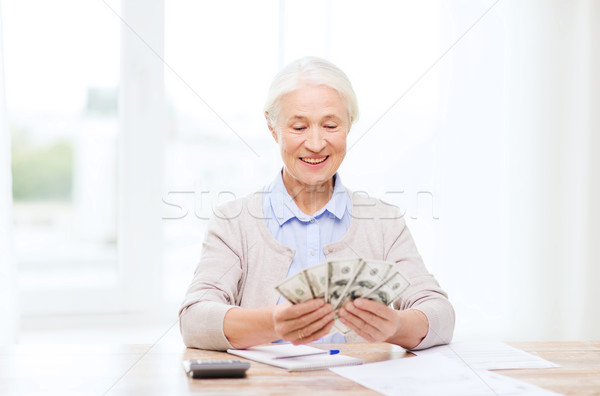 senior woman with money and papers at home Stock photo © dolgachov