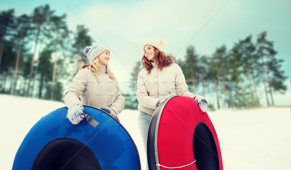 Stock photo: happy girl friends with snow tubes outdoors