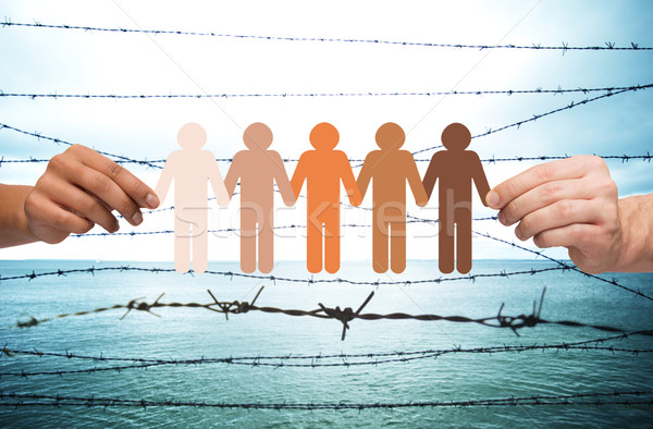 hands holding people pictogram over barb wire Stock photo © dolgachov
