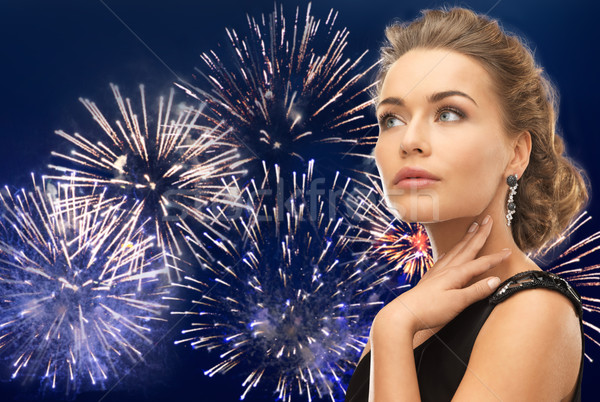 beautiful woman wearing earrings over firework Stock photo © dolgachov