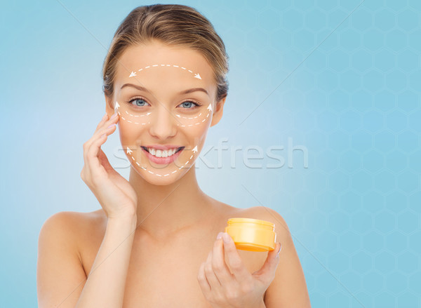 happy young woman applying cream to her face Stock photo © dolgachov