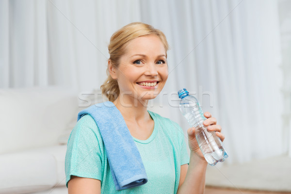 happy woman drinking water and exercising at home Stock photo © dolgachov
