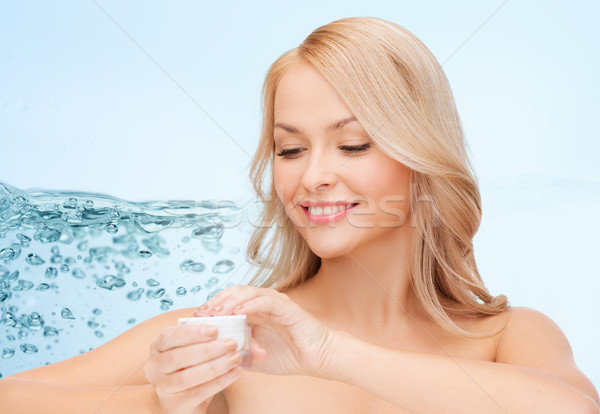 woman applying moisturizing cream to her face skin Stock photo © dolgachov