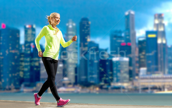 happy woman jogging over city street background Stock photo © dolgachov