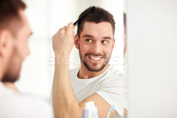 Heureux homme cheveux peigne salle de bain beauté [[stock_photo]] © dolgachov