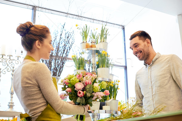 Stock photo: smiling florist woman and man at flower shop
