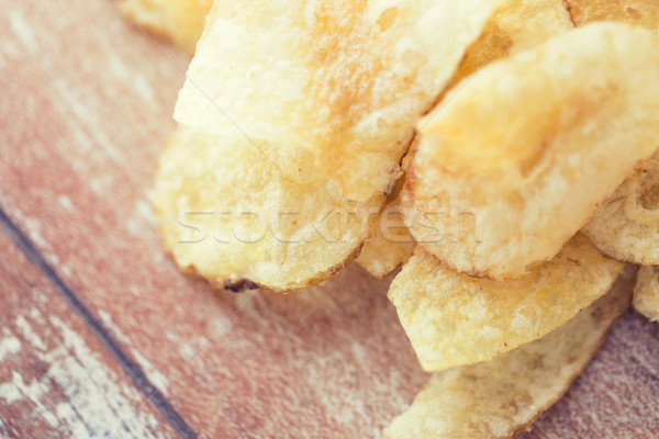close up of crunchy potato crisps on wooden table Stock photo © dolgachov