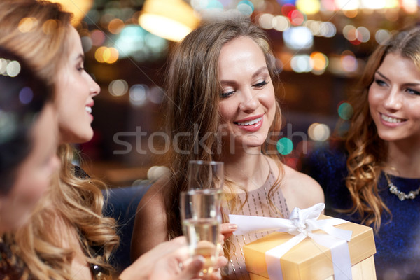 happy women with champagne and gift at night club Stock photo © dolgachov
