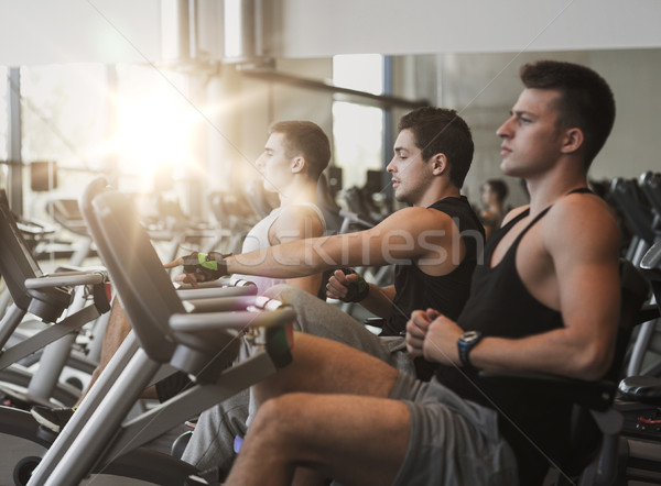 men working out on exercise bike in gym Stock photo © dolgachov