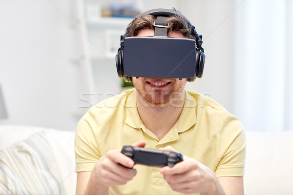 man in virtual reality headset with controller Stock photo © dolgachov