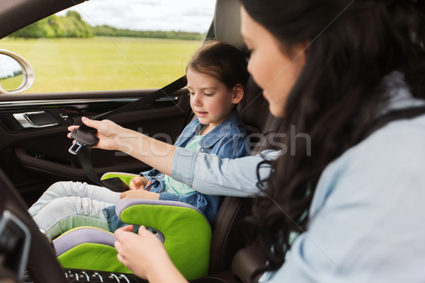 happy woman fastening child with seat belt in car Stock photo © dolgachov