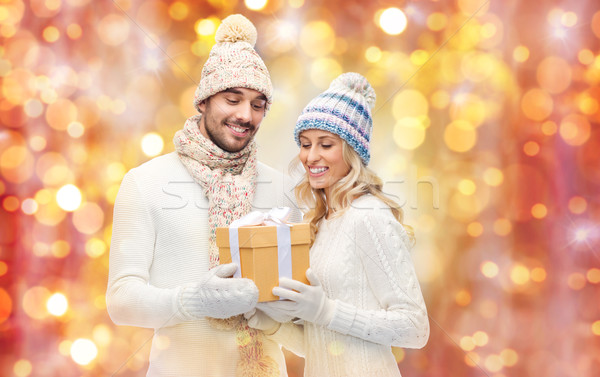 smiling couple in winter clothes with gift box Stock photo © dolgachov