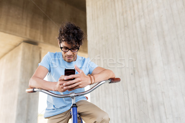man with smartphone and fixed gear bike on street Stock photo © dolgachov