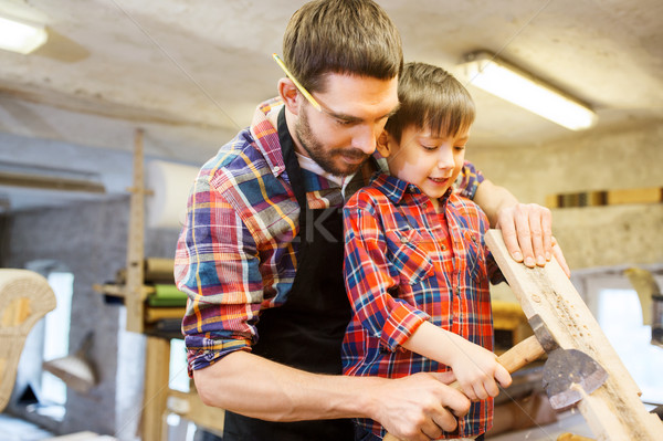father and son with ax and wood plank at workshop Stock photo © dolgachov