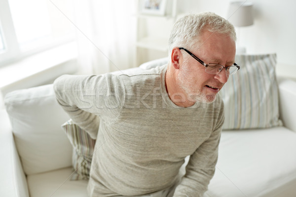 unhappy senior man suffering from backache at home Stock photo © dolgachov