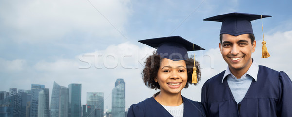 students or bachelors in mortar boards over city Stock photo © dolgachov