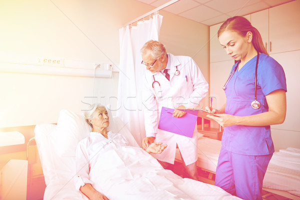 doctor and nurse visiting senior woman at hospital Stock photo © dolgachov