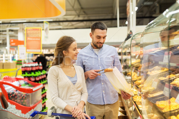 happy couple with shopping cart at grocery store Stock photo © dolgachov