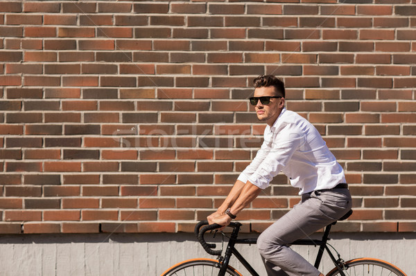 young man riding bicycle on city street Stock photo © dolgachov