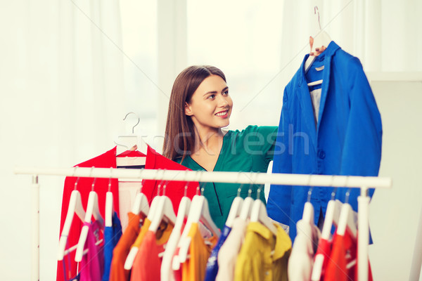 Stock photo: happy woman choosing clothes at home wardrobe