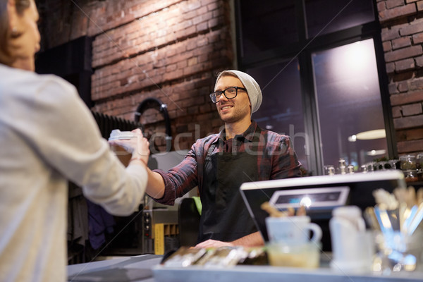 Stock photo: seller giving coffee cup to woman customer at cafe