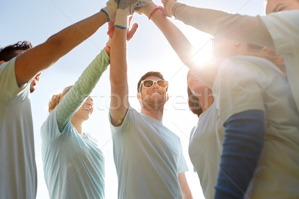 group of volunteers making high five outdoors Stock photo © dolgachov