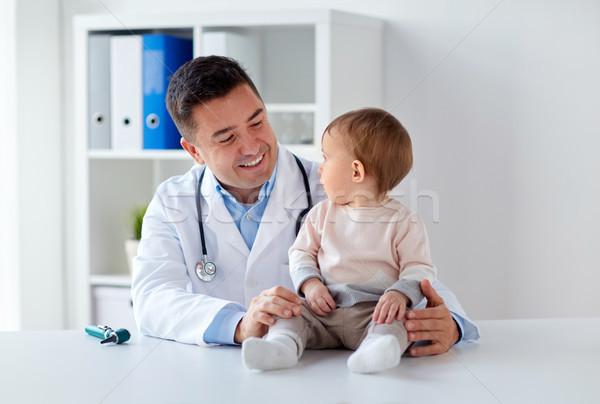 Stock photo: happy doctor or pediatrician with baby at clinic