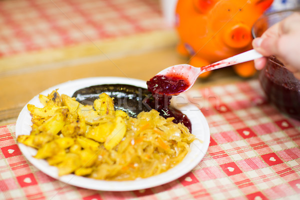 hand pouring sausages with cranberry sauce Stock photo © dolgachov