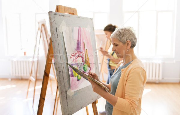woman artist with easel painting at art school Stock photo © dolgachov