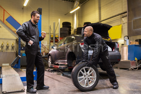 auto mechanics changing car tires at workshop Stock photo © dolgachov