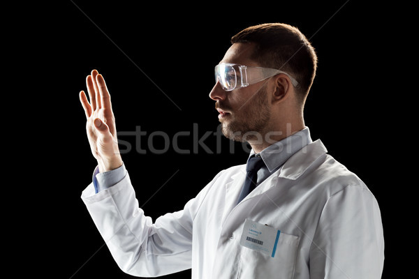 doctor or scientist in lab coat and safety glasses Stock photo © dolgachov