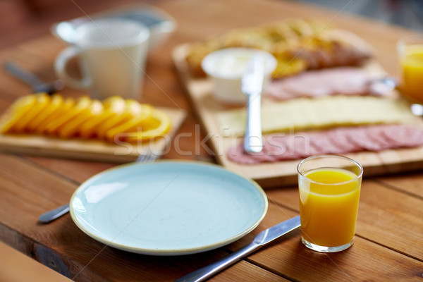 plate and glass of orange juice on table with food Stock photo © dolgachov