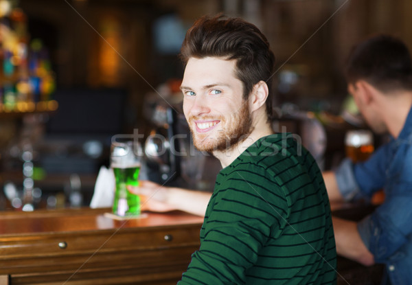 happy man drinking green beer at bar or pub Stock photo © dolgachov