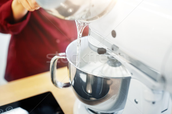 chef pouring ingredient from pot into mixer bowl Stock photo © dolgachov