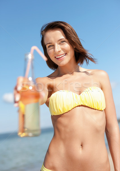girl with bottle of drink on the beach Stock photo © dolgachov