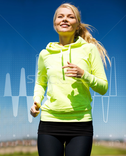 smiling woman jogging outdoors Stock photo © dolgachov