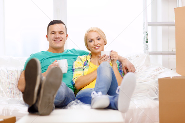 smiling couple relaxing on sofa in new home Stock photo © dolgachov
