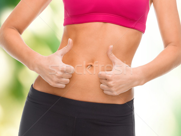 close up of female abs and hands showing thumbs up Stock photo © dolgachov