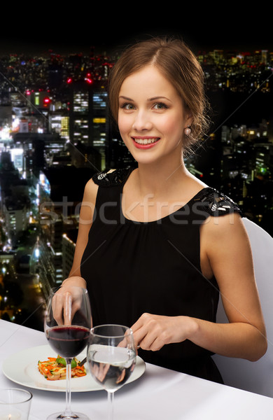 smiling young woman eating main course Stock photo © dolgachov