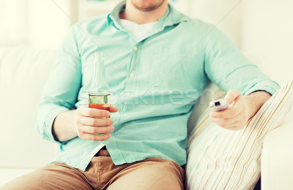 man with beer and remote control at home Stock photo © dolgachov
