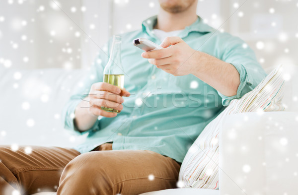 man with beer and remote control at home Stock photo © dolgachov