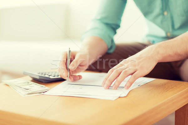 Stock photo: close up of man counting money and making notes