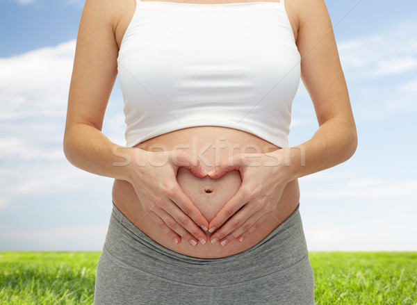 close up of pregnant woman touching her bare tummy Stock photo © dolgachov