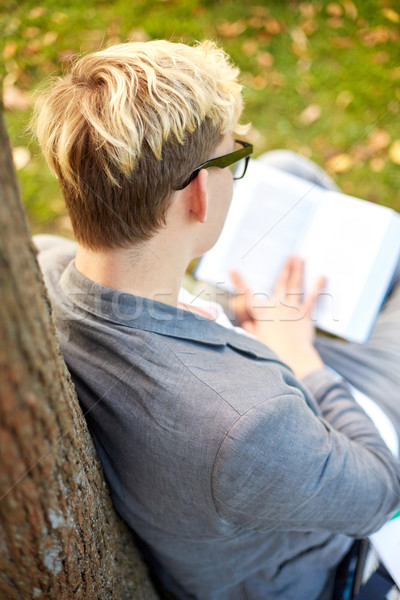 teenage boy or young man reading book outdoors Stock photo © dolgachov