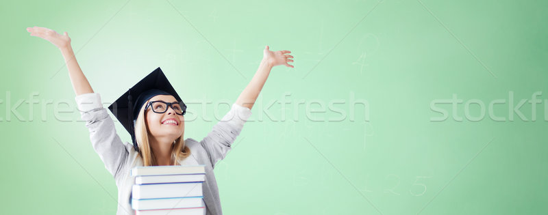 happy student in mortar board cap with books Stock photo © dolgachov