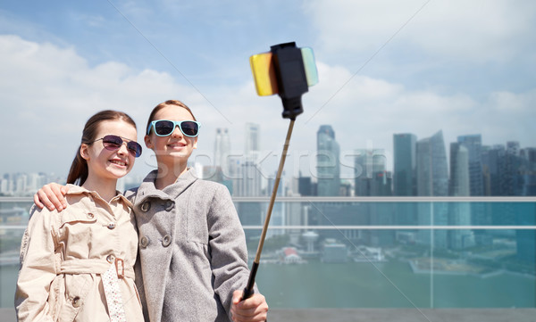 girls with smartphone selfie stick in singapore Stock photo © dolgachov