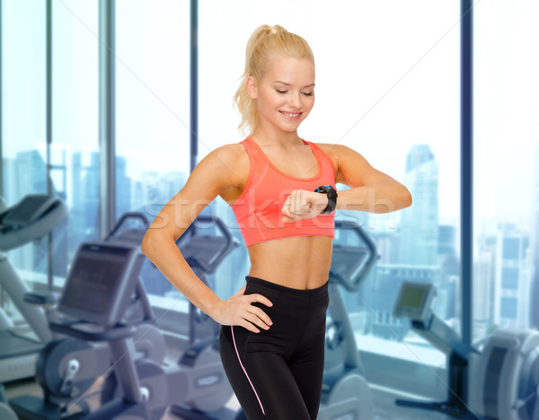 微笑的女人 看 心臟率 看 健身房 健身 商業照片 © dolgachov