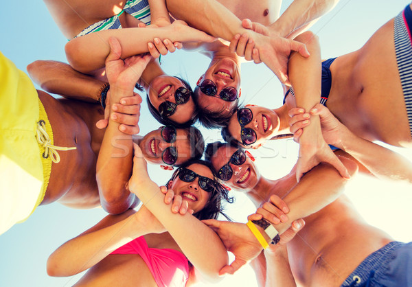 smiling friends in circle on summer beach Stock photo © dolgachov